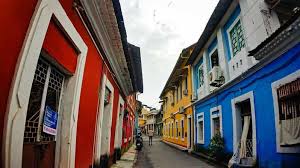 Fontainhas Quarter - Narrow street lined with colorful Portuguese-style houses in vibrant red, blue, and yellow hues, with traditional tiled roofs and balconies